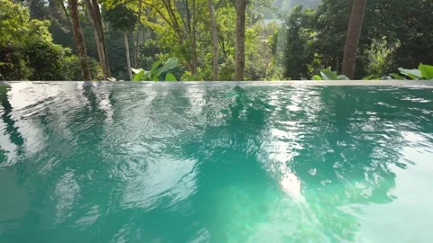Tranquil infinity pool overlooking a lush tropical rainforest Stock Footage 337952176