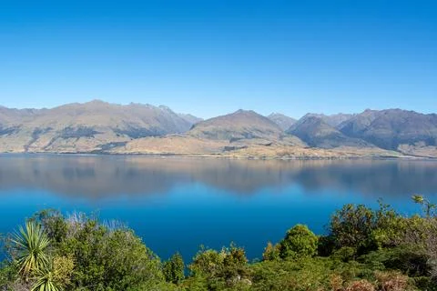 Tranquil Lake and Mountain Reflection Under Clear Blue Sky Stock Photos