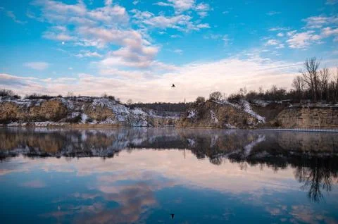 Tranquil Lake with Cliffs and Bird in Flight Stock Photos