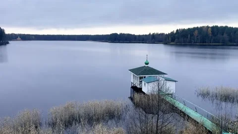 Tranquil Lake with Cozy Dock and Cabin Scene with an Orthodox cross on top 動画素材 319957737