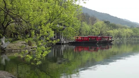 Tranquil Lake with Green Foliage and Traditional Chinese Red Structure Stock Footage 340267765
