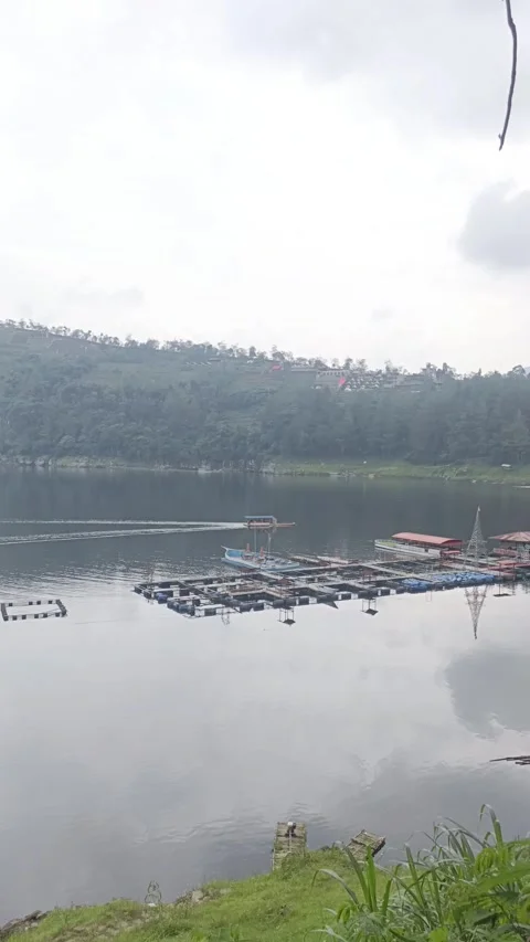 Tranquil lake landscape with floating docks and distant hill Stock Footage 304114338