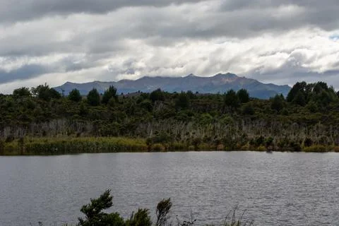 Tranquil Lake with Mountain View Under Cloudy Sky Stock Photos