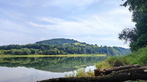 Tranquil Lake Reflection with Forested Hills and Peaceful Shoreline Photos