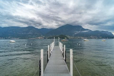 A tranquil lake scene featuring a long pier extending into calm waters Stock Photos
