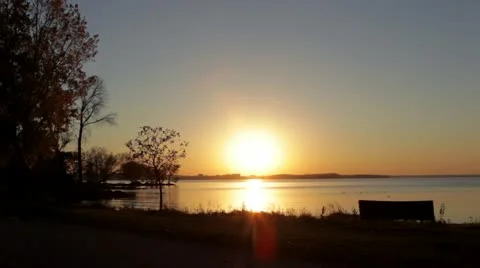 Tranquil lake at sunset, couple walking silhouette Stock Footage 12370901