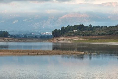 A tranquil landscape with a dramatic sky over Lake Beniarres 스톡 사진