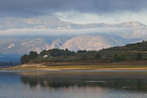 A tranquil landscape with a dramatic sky over Lake Beniarres Stock Photos