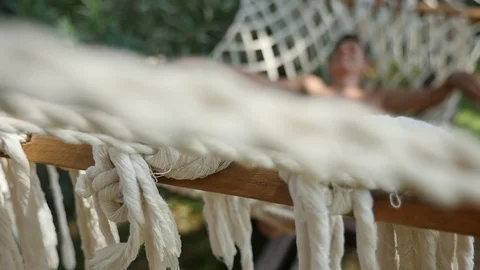 Tranquil man is sleeping in an exotic hammock with spread legs in slow motion Stock-Footage 96424813