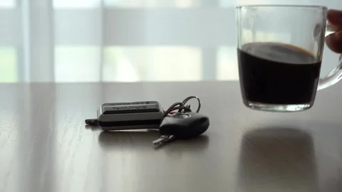 A Tranquil Moment Captured: Coffee and Keys on a Table Bathed in Soft Light Stock Footage 346740535