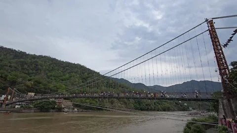 A Tranquil Moment by the Ganges and Rishikesh Bridge Stock Footage 313564438