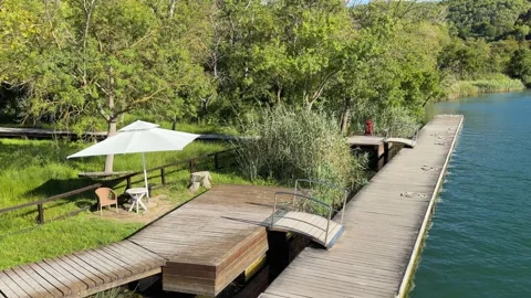 Tranquil Nature Scene: Empty Table and Chair on Wooden Dock Video stock 347162831