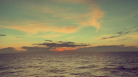 Tranquil ocean at sunset with colorful sky and scattered clouds over the ho.. Stock Footage 338281716