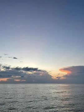 Tranquil Ocean Sunset with Dramatic Clouds and Soft Evening Light Stock Photos
