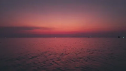 Tranquil ocean surface glowing at sunset. Calm sea reflecting beautiful purple Stock Footage 312744676