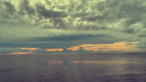 Tranquil ocean view under a dramatic sky with clouds and the sun setting on.. Stock Footage 338281780