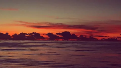 Tranquil Ocean Waves at Sunset with Vibrant Orange and Purple Sky Stock Footage 338281742