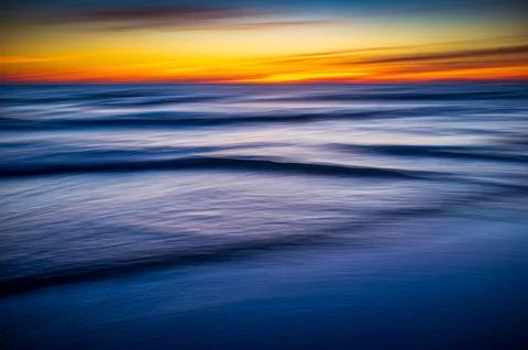 Tranquil Ocean Waves Under Vibrant Sunset Sky Stock Photos