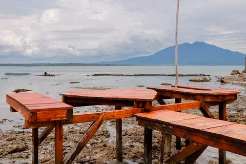 Tranquil Oceanside Picnic Platforms with Distant Mountain View Scenery Stock Photos