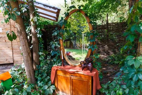 A Tranquil Outdoor Scene Featuring a Rustic Mirror Surrounded by Lush Greenery Stock Photos