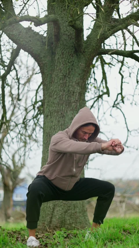 Tranquil outdoor setting featuring an individual engaged in yoga practice nearby Stock Footage 294615960