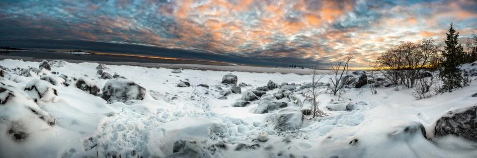 A tranquil panoramic landscape of cloud covered sky and snow covered half fro Stock Photos