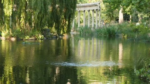 Tranquil Park Pond with Classical Corinthian Columns Framed by a Weeping Willow  Stock Footage 340477460