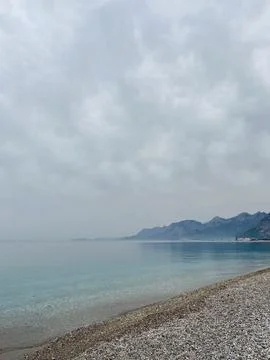 Tranquil Pebble Beach Under a Cloudy Sky Foto stock