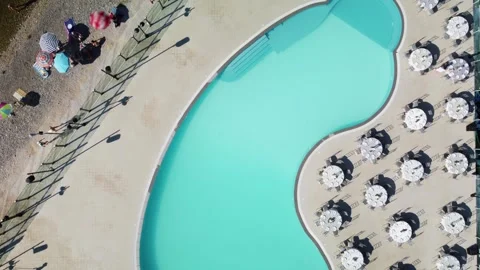Tranquil Poolside and Beach: Aerial View of Set Tables, Parasols, and People Stock Footage 318121131