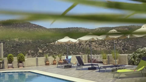 A tranquil poolside setting with deck chairs and umbrellas, Greece Stock Footage 328658715