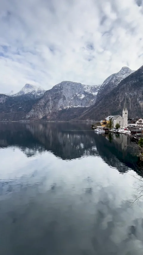 Tranquil reflections of an alpine lake surrounded by snow-capped mountains Stock Footage 302160526