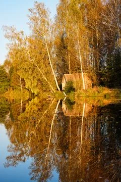 Tranquil Reflections: House and Trees Mirrored in River Stock Photos
