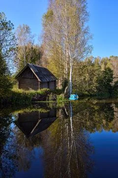 Tranquil Reflections: House and Trees Mirrored in River Stock Photos