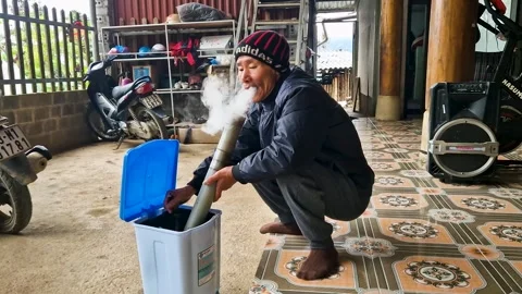 Tranquil Reflections: Vietnamese Elder Enjoying a Tobacco Bong Stock Footage 240877224
