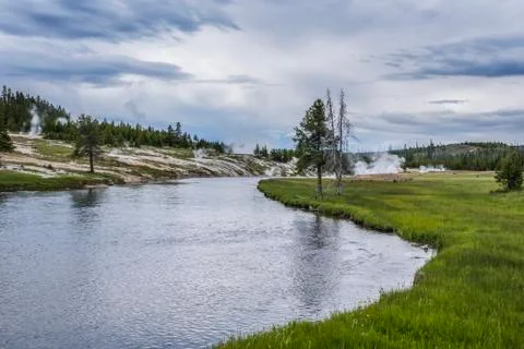 Tranquil river and grass under a cloudy sky, Grand Teton National Park Stock Photos