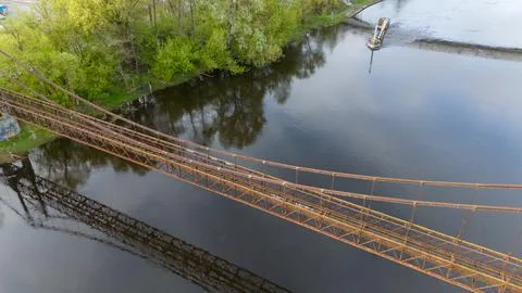 Tranquil River with old pipeline Bridge and Lush Greenery Stock Photos