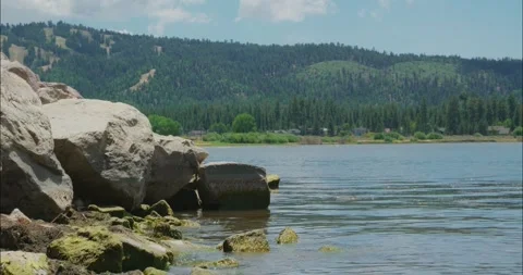 Tranquil River Scene with Rocks and Forested Hills Stock Footage 323365253