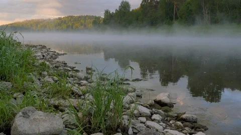 Tranquil river with spreading thick fog and stones on bank Stock-Footage 109694891