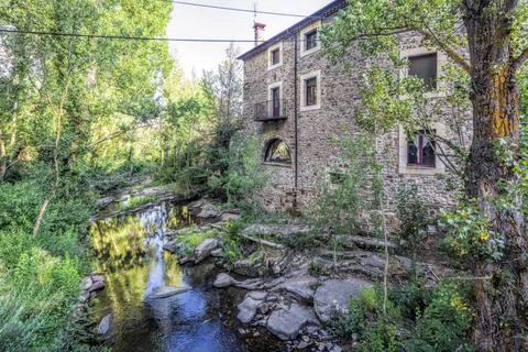 Tranquil River Tera Alongside a Stone Building in Almarza, Soria Stock Photos