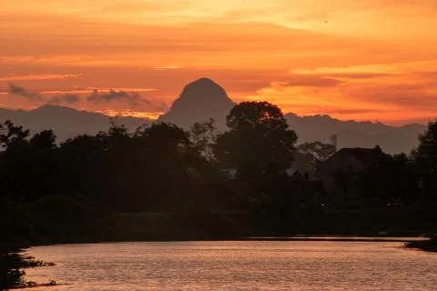 Tranquil river at twilight featuring a mountain background Stock Photos