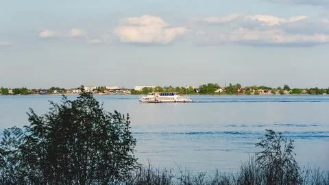 A tranquil river view with a ship in the distance and calm water under a cl.. Photos