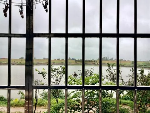 "Tranquil River View Through a Metal Fence" Stock-Fotos