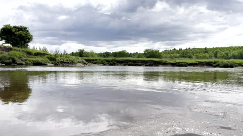 Tranquil River Water Surface with Forested Bank Under Cloudy Sky Video stock 311583862