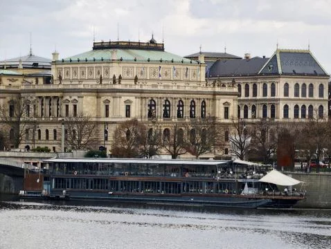 Tranquil Riverbank Setting Showcasing Elegant Vessel Parked Near Ornate Neo.. Stock-Fotos