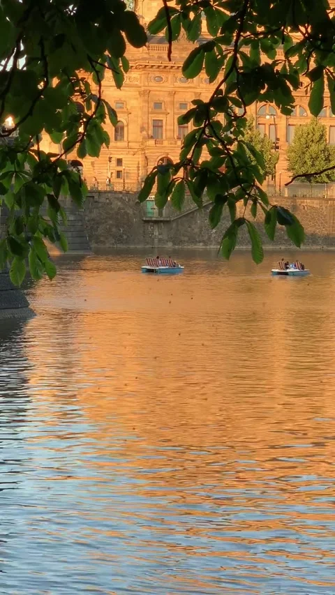 A tranquil riverside scene at sunset, with golden reflections on the water, fram Stock Footage 296284937