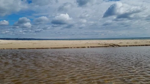 Tranquil sandy beach with sea waves under cloudy blue sky Stock Footage 319252471