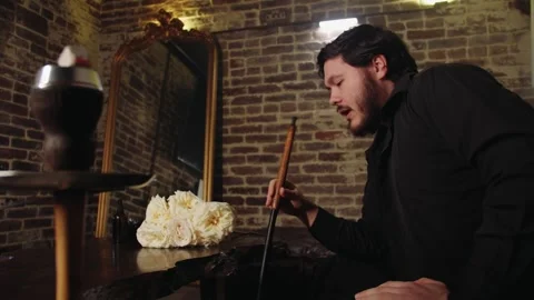 Tranquil scene featuring man relaxing with hookah in vintage lounge environment Video stock 331882470