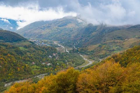 Tranquil Scene with Fluffy Clouds and Vibrant Autumn Mountain Range Stock Photos