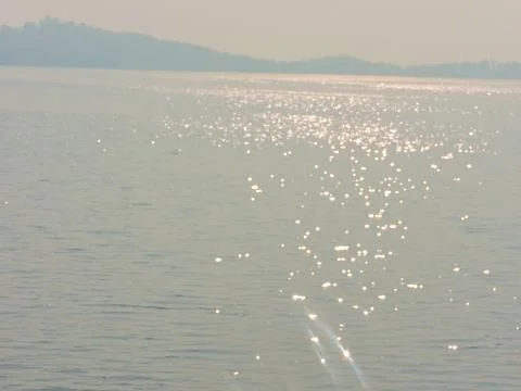 Tranquil scene of sunlight reflecting off the surface of a body of water Stock Photos