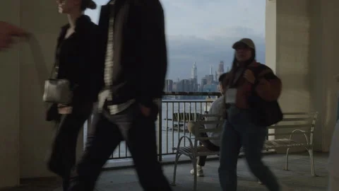 A tranquil scene of an unrecognizable man sitting along The East River Stock Footage 273543491